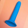 Blue Ainsley toy with suction cup base silicone on orange background